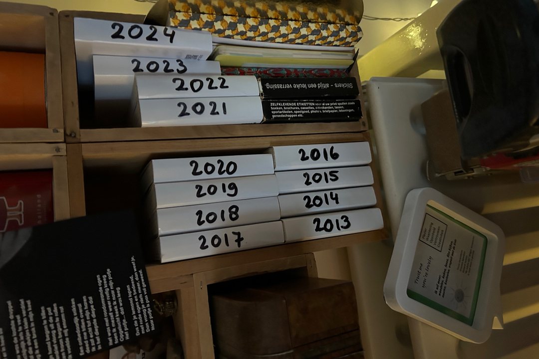 A shelf of PYM yearbooks, one for every year from 2013 to 2024